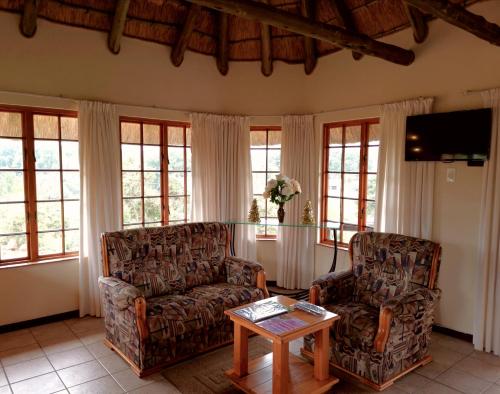 a living room with two chairs and a coffee table at Otters Den in Nottingham Road