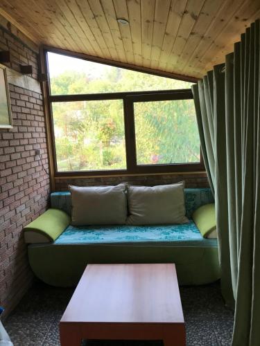 a couch in a room with a large window at маленькое шале в с.Строенцы in Stroieşti