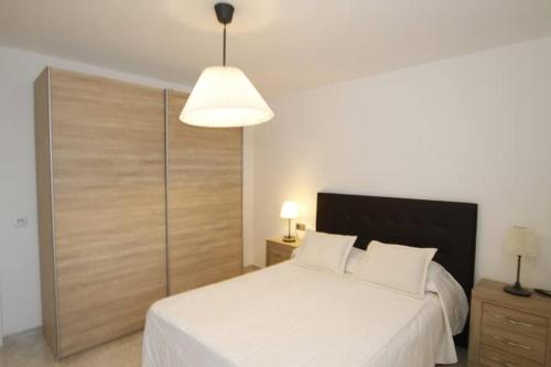 a bedroom with a large white bed with a large headboard at Apartamento Yale in Tías