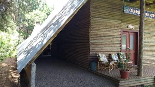 two chairs sitting on the porch of a cabin at CHALÉ ESTÂNCIA OURO VERDE in Lages