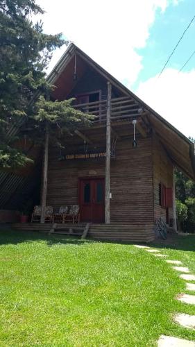 a log cabin with a porch and chairs in front of it at CHALÉ ESTÂNCIA OURO VERDE in Lages