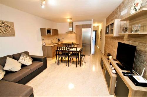 a living room with a couch and a dining room at Apartamento Yale in Tías