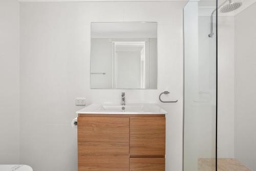 a bathroom with a sink and a mirror at Whitesands 501 in Forster
