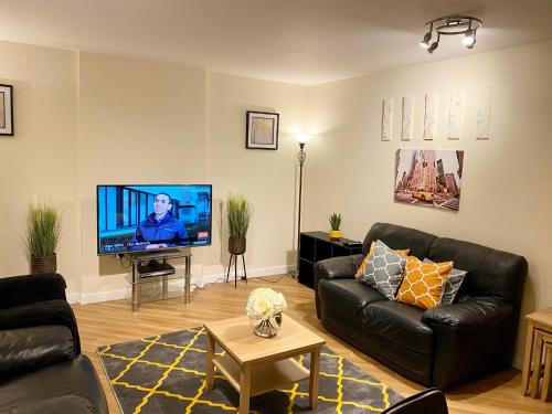 a living room with a couch and a flat screen tv at Smartrips Apartments - The Hub in Milton Keynes