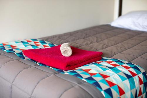 a red towel sitting on top of a bed at Fitzgerald on King in Timaru