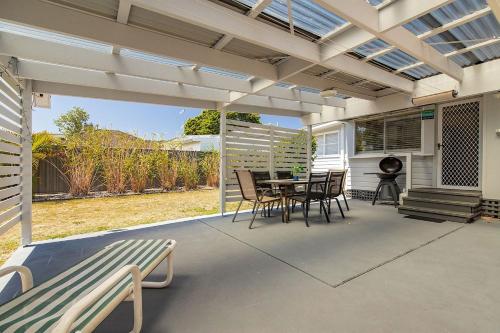 a patio with a table and chairs and a bench at Douglas Avenue 5 in Forster