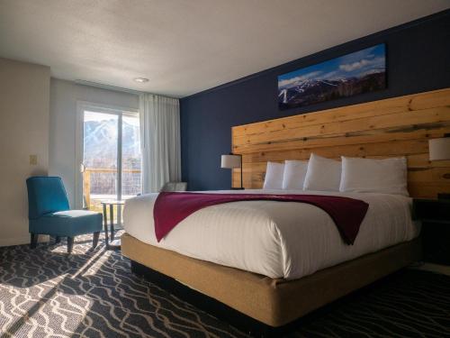 a bedroom with a large bed and a blue wall at Mountain Inn at Killington in Killington