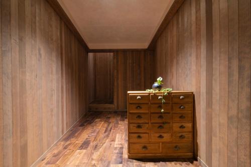 HOTEL 101 KANAZAWA في كانازاوا: غرفة بجدران خشبية وخزانة خشبية