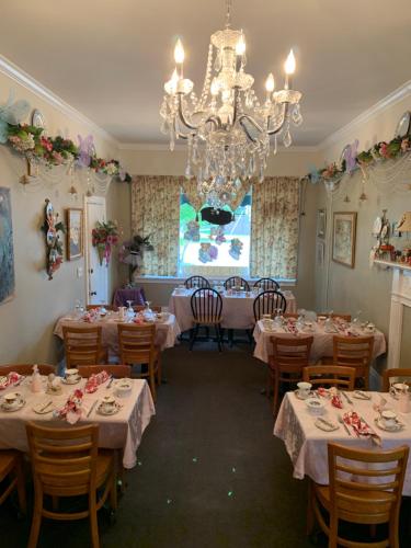 a dining room with tables and a chandelier at Emerald Necklace Inn Bed and Breakfast in Lakewood