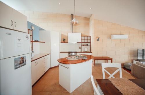 eine Küche mit einem weißen Kühlschrank und einem Tisch in der Unterkunft Bayview no 1 in Port Campbell