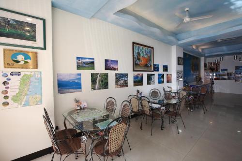 花蓮市的住宿－漫遊舍民宿，用餐室配有桌椅,墙上挂有图片