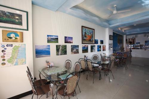 una sala da pranzo con tavoli, sedie e quadri alle pareti di Cruise Homestay a Città di Hualien