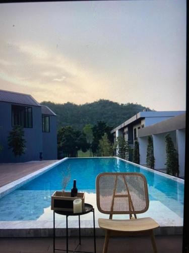 a view of a swimming pool with a table and chairs at Adoor hotel Khao Yai in Ban Rai