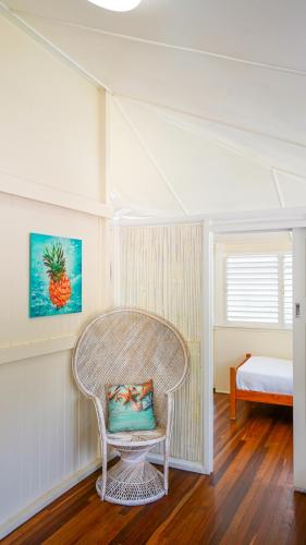 a wicker chair with a pillow in a room at Daggoombah Holiday Home Magnetic Island in Arcadia