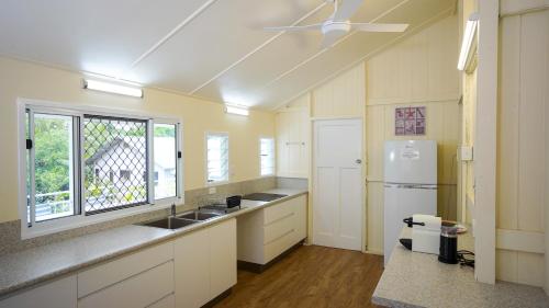 a large kitchen with a sink and a window at Daggoombah Holiday Home Magnetic Island in Arcadia