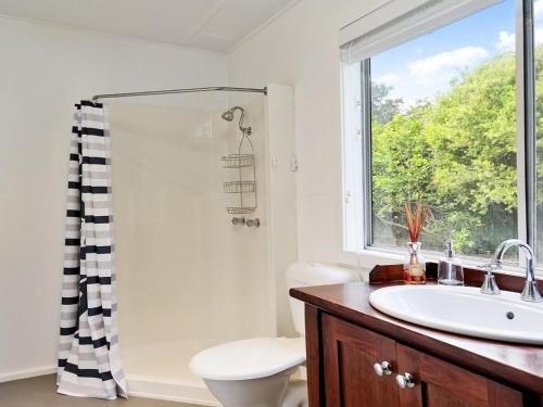 a bathroom with a sink and a toilet and a window at Gone Fishing in Culburra Beach