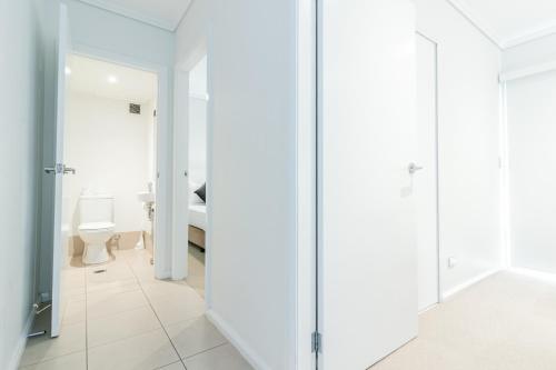 a bathroom with white walls and a toilet at Absolute Beachfront Opal Cove Resort in Coffs Harbour