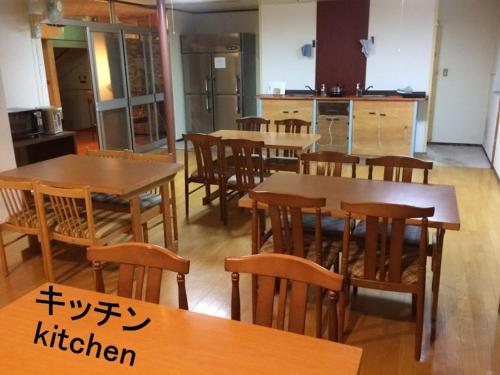 a kitchen with wooden tables and wooden chairs at ふる郷荘Furusato Furano in Furano