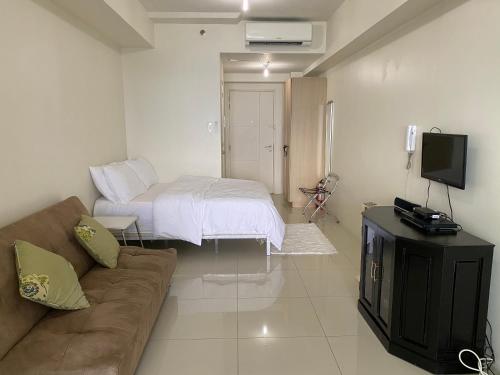 uma sala de estar com um sofá e uma cama em Wind Residences Tagaytay em Tagaytay