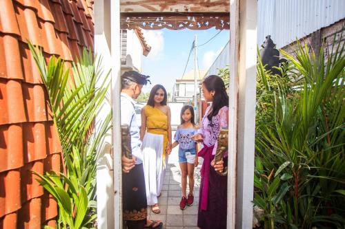 a family walking through the door of a house at Puri Lumbung Village in Payangan