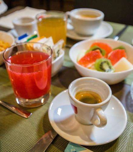 a table with a cup of tea and a bowl of fruit at Hotel Europa Art Caserta in Caserta