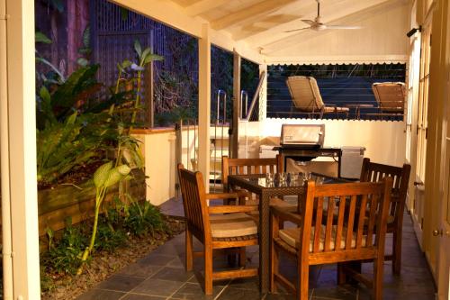 a screened in porch with a table and chairs at Port Douglas Cottage & Lodge in Port Douglas