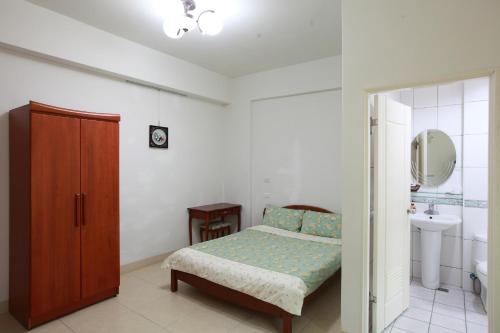 1 dormitorio con cama, lavabo y espejo en Travelers Fu-Home, en Hualien City
