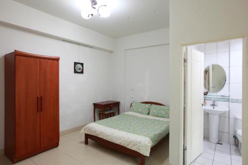 a bedroom with a bed and a sink and a mirror at Travelers Fu-Home in Hualien City