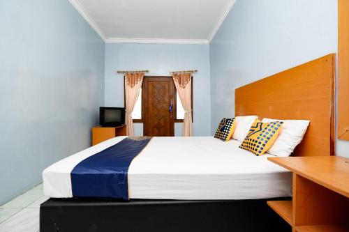 Ένα ή περισσότερα κρεβάτια σε δωμάτιο στο OYO 2240 Simpang Tujuh Residence