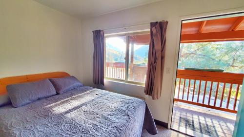 a bedroom with a bed and a large window at Corral Creek Lodge in Kernville