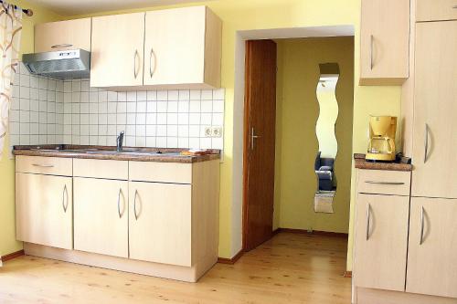 a kitchen with white cabinets and a sink at Haus Leutner in Bodenmais