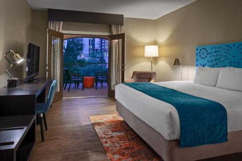 a hotel room with a bed and a desk and a television at Hotel Indigo San Antonio Riverwalk by IHG in San Antonio