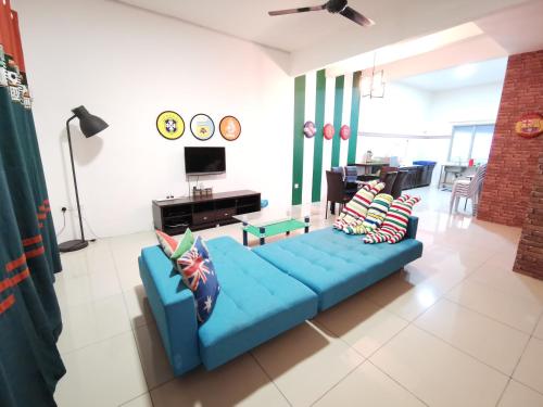 a living room with a blue couch with pillows at The Woodz Homestay - 2 Storey Landed House in Cameron Highlands