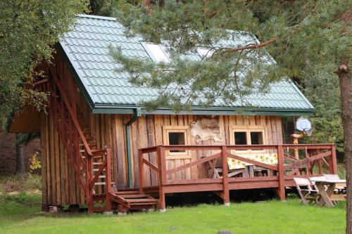 a large wooden cabin with a porch and a deck at Yurtos in Gaugariai