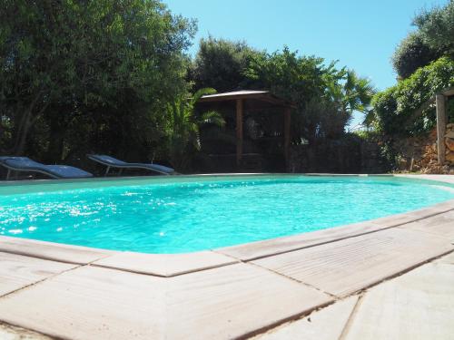 a large blue swimming pool with a gazebo at Domaine de la Borie in Trans-en-Provence