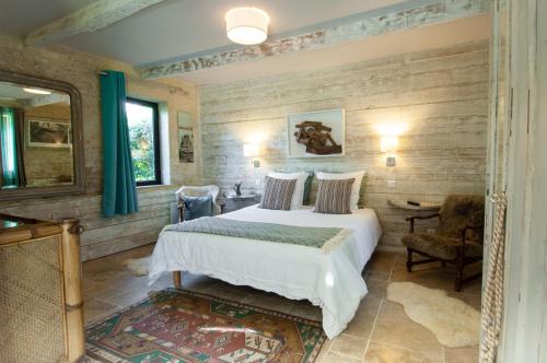 a bedroom with a bed and a table and a chair at Domaine du Lieu des Brocs - Country Club in Brucourt