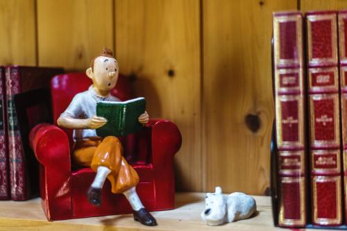 a toy man sitting in a chair reading a book at Le Petit Domaine de Bois Avril in Étais-la-Sauvin