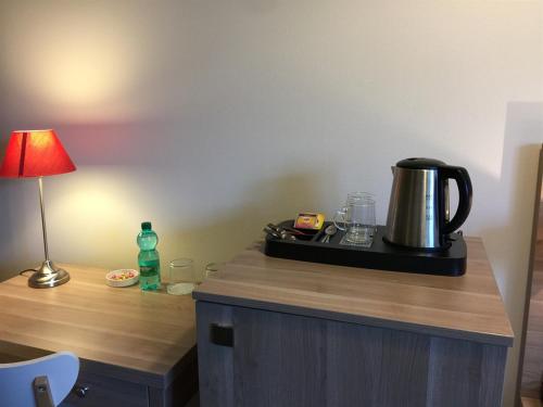 - une table avec une cafetière et une lampe dans l'établissement Storia Da Ennio, à La Verrière