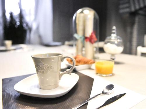 eine Kaffeetasse auf einem Teller auf einem Tisch in der Unterkunft Le Château d'Orleix in Orleix