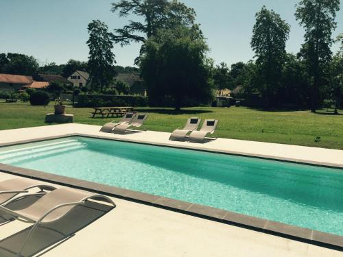 a swimming pool with four lounge chairs in a yard at Le Château d'Orleix in Orleix