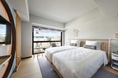 a bedroom with a large bed and a large window at Mercure Kyoto Station in Kyoto