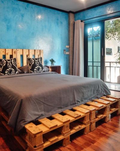 a bedroom with a large bed with blue walls at Baan Rabieng Talay Homestayบ้านระเบียงทะเล โฮมสเตย์เกาะกูด in Ko Kood