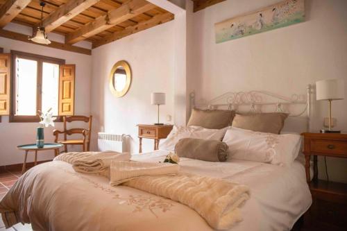 ein Schlafzimmer mit einem großen Bett mit weißer Bettwäsche in der Unterkunft Mirador del Vadillo in La Velilla