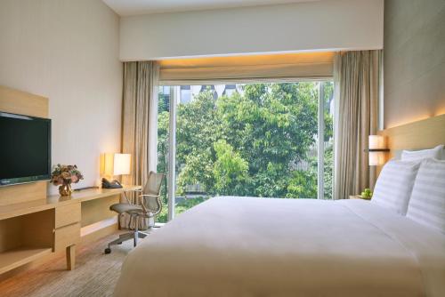 Oasia Resort Sentosa by Far East Hospitality في سنغافورة: غرفة فندقية بسرير ونافذة كبيرة