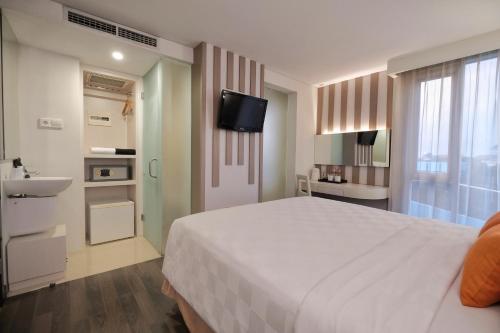 Postel nebo postele na pokoji v ubytování All Nite & Day Hotel Yogjakarta - Gejayan