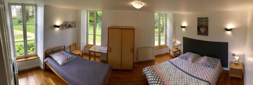 a living room with two beds and two windows at Château du Bourg in Saint-Denis-de-Gastines