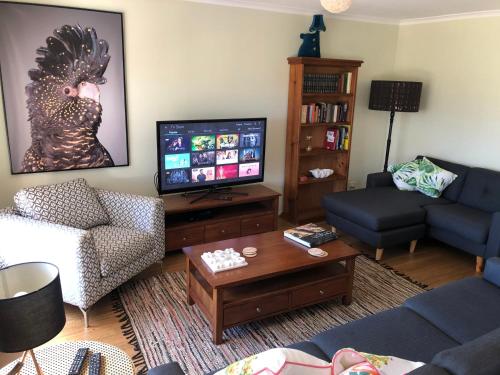 a living room with a couch and a tv at 225 on Myall in Tea Gardens