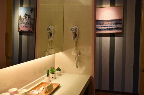 a bathroom with a sink with a phone and a mirror at South Island 206 in Hengchun