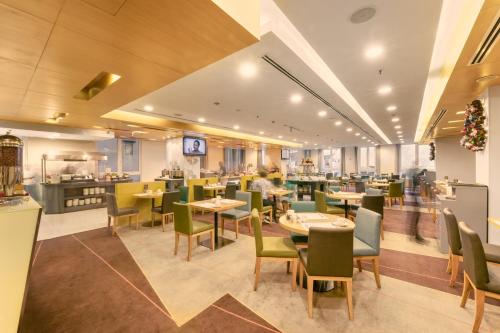 a restaurant with tables and chairs and a kitchen at Liberty Central Saigon Centre Hotel in Ho Chi Minh City