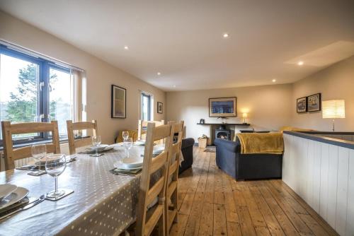 a dining room and living room with a table and a couch at Rock Cottage - 3 Bedroom Holiday Home - Fishguard in Fishguard